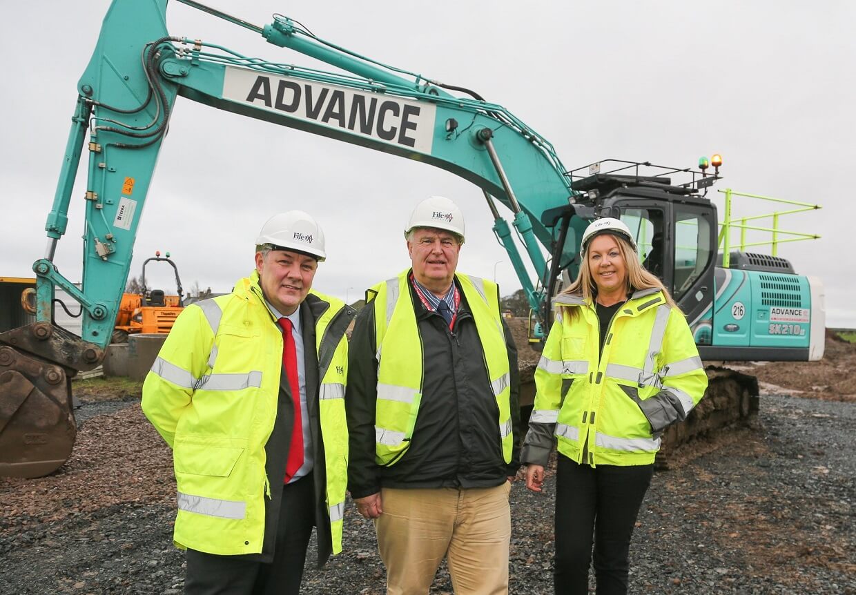 Three people in high visibility vests standing in front of a large digger - Levenmouth Business Park Takes Shape