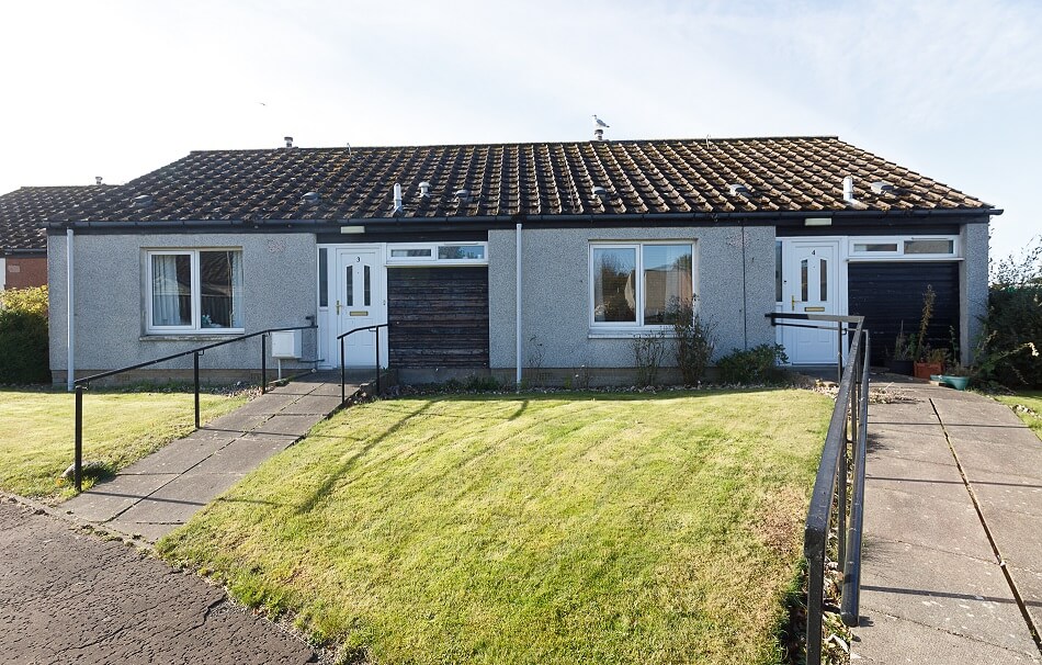 Exterior of semi-detached bungalows at Scooniehill, with front gardens