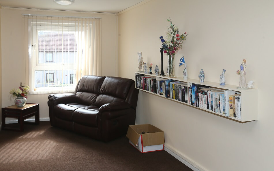 Reading corner at Lismore Place, with plush sofa chair and bookcase full of books