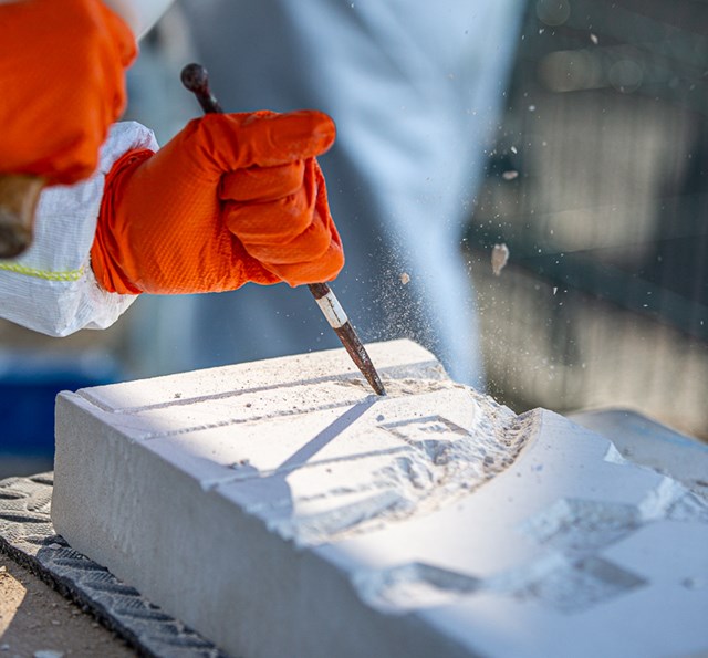 Carving the school logo into stone