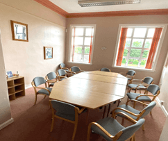 Room with a large table surrounded by chairs