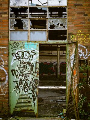 photo of building with broken windows and graffiti 