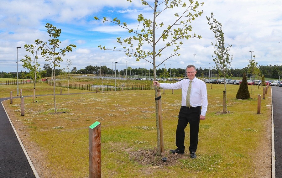 Principal Biology teacher, Alan Runciman, standing beside the young tree trail