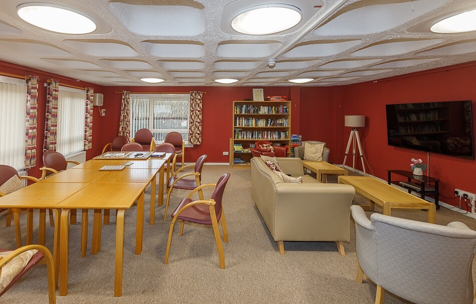 Communal lounge at Allan Court, with sofa and armchairs and dining table