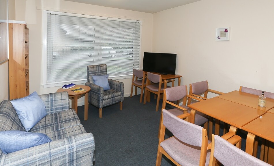 Communal seating and dining area at Patterson Place, with TV in the corner