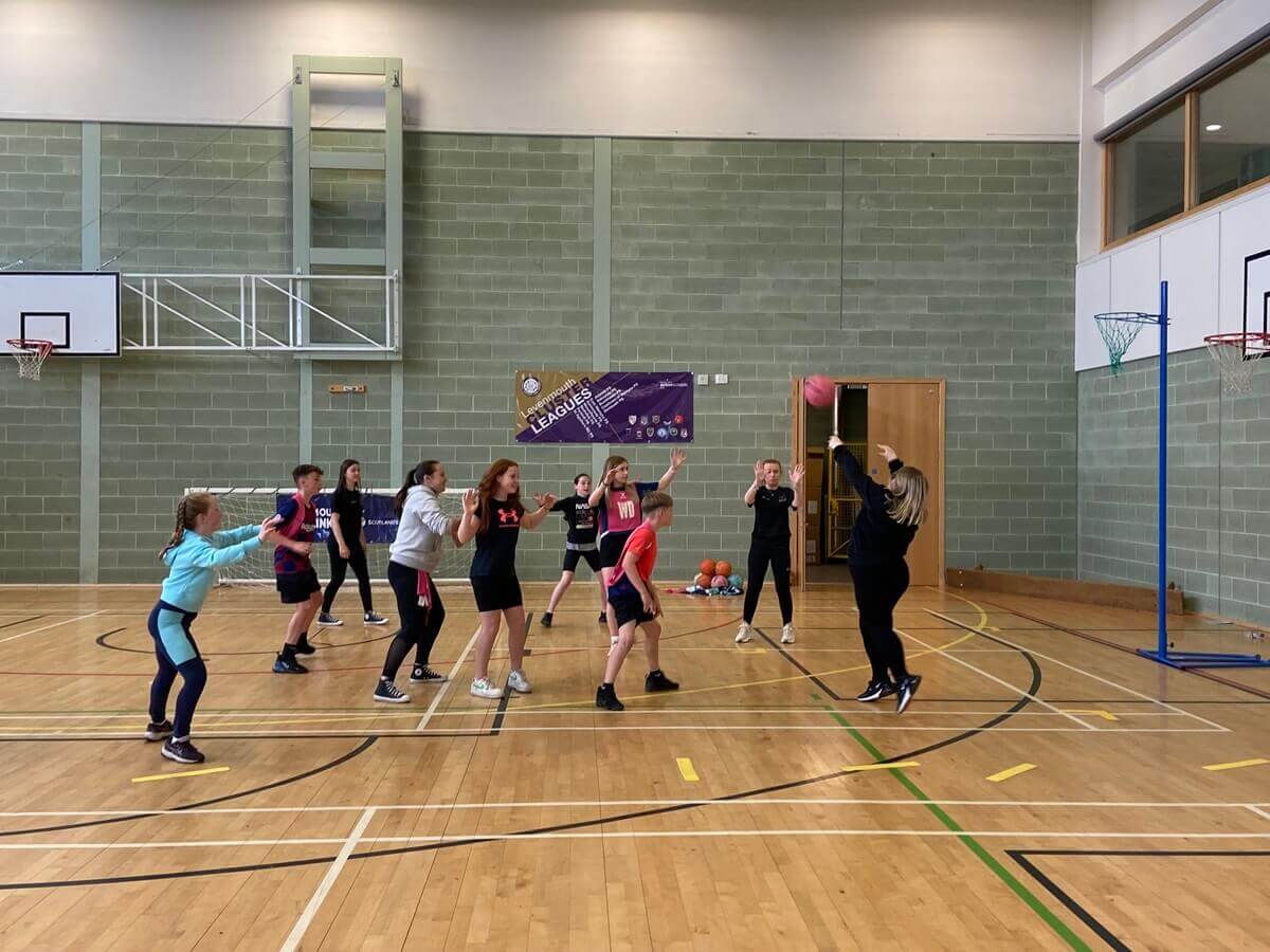 Group of young people playing netball in an indoor sports hall. - £100,000 Summer of Sport Fund opens for Fife clubs and community groups