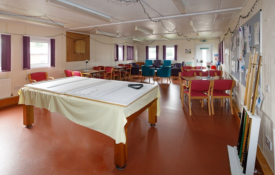 Internal communal area, with pool table and several tables and chairs set up