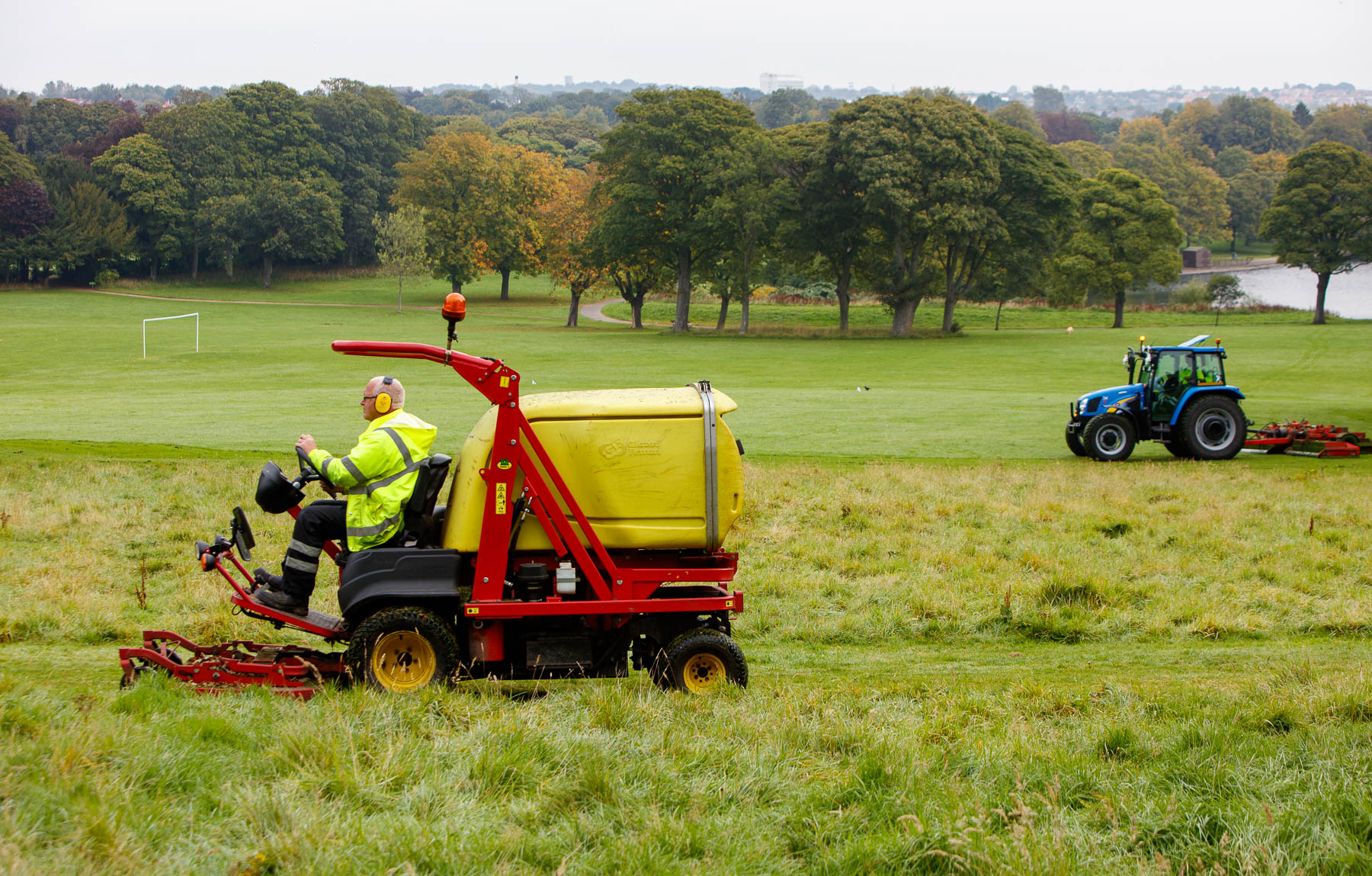 Council staff cutting a path through long grass