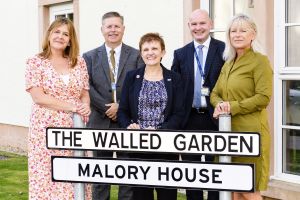 Representatives from Bield Housing and Fife Council stand next to Malory House sign 