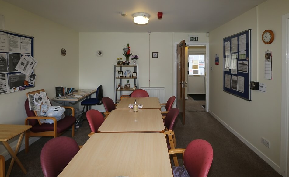 Dining area at Broomside, with long communal table and 6-8 chairs around it.