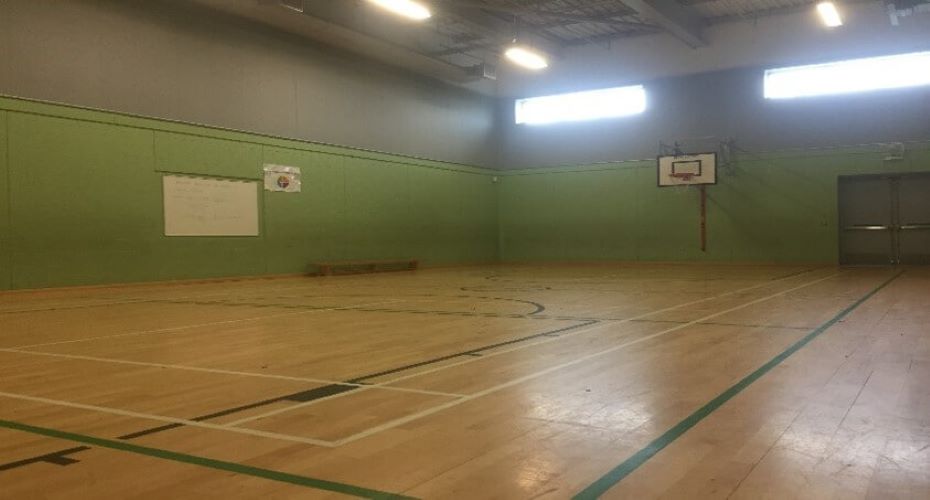 Gym with court markings and basketball hoop