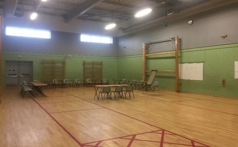 Gym with tables and chairs set out at one end