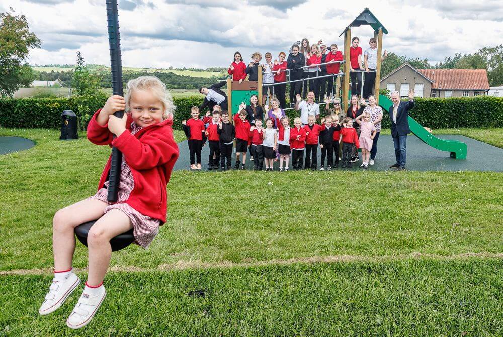 Children and adults enjoying new play park equipment