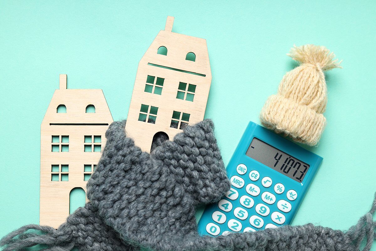 graphic of a house wrapped in a scarf next to a calculator with a hat on
