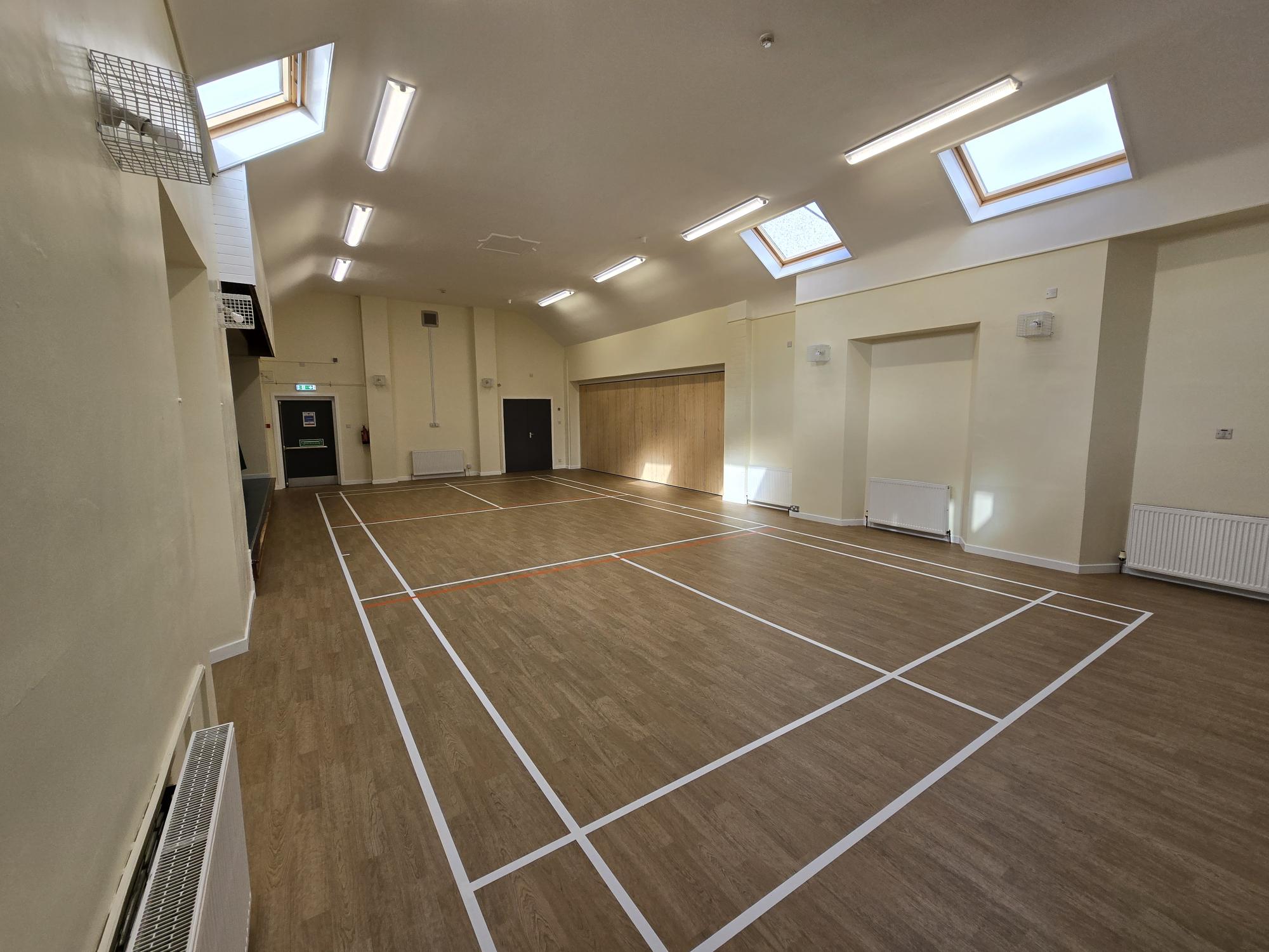 Saline-CC-Main-Hall.jpg Community hall with wooden floor marked with court lines and roof lights