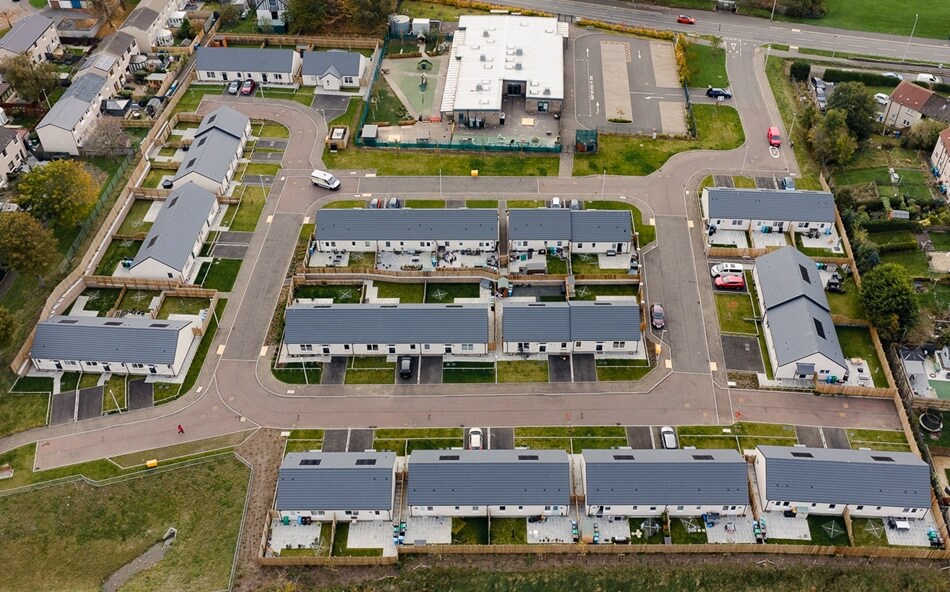 Aerial view of Lathalmond Square, looking down on houses with grey roofs and white facades, with roads and pathways leading to each property