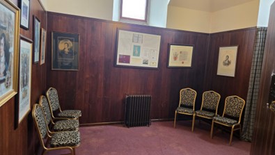 The supper room with red carpet, chair and photos on the wall