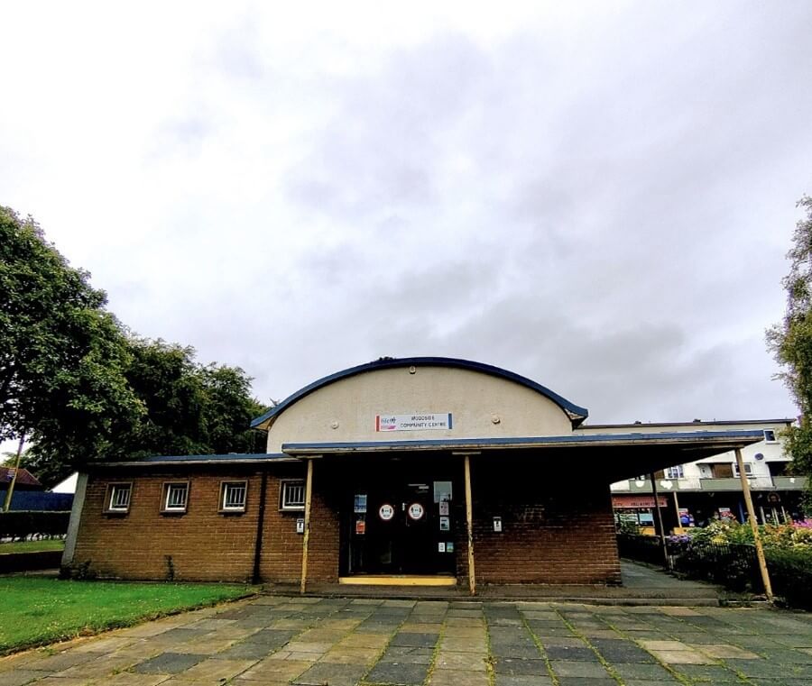 Front of Woodside Community Centre building with a curved roof and brick exterior