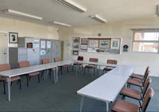 Meeting room with long tables set out in a 'U' shape with chairs around the outside.