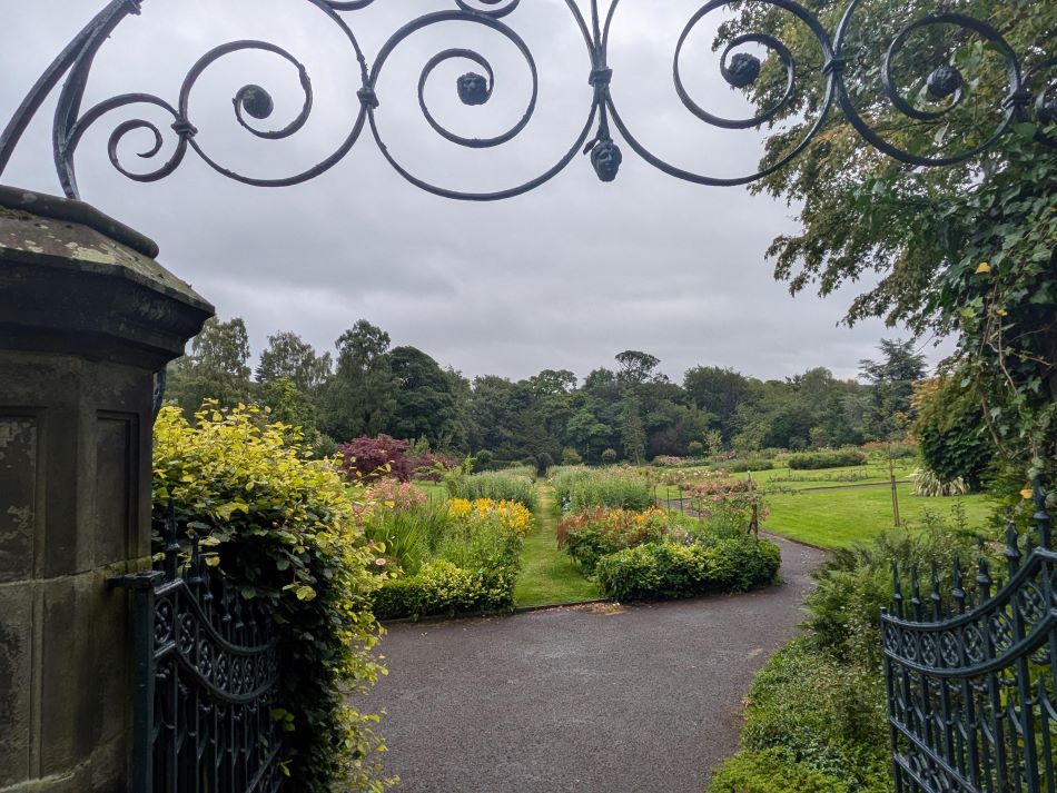 Ornamental gardens in Pittencrieff Park framed by a wrought iron gateway