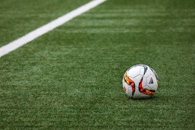 Football sitting on a grass pitch