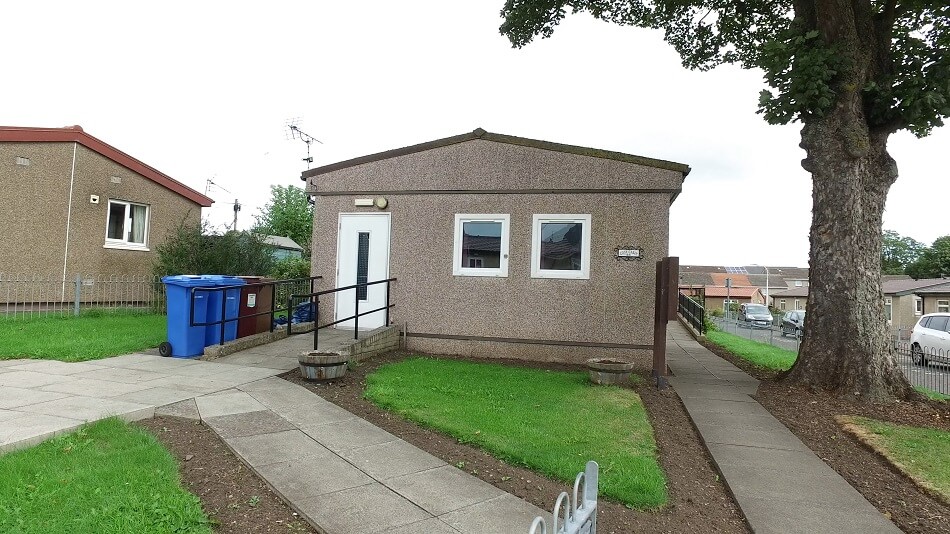 Exterior of bungalow, with grassy area to the front