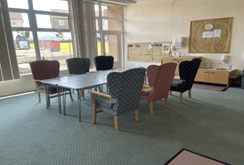 Meeting room with a large table surrounded by comfortable chairs.
