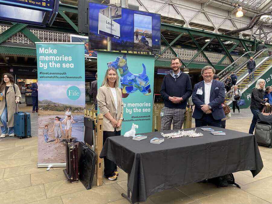 A group of people standing next to a table at the Expo