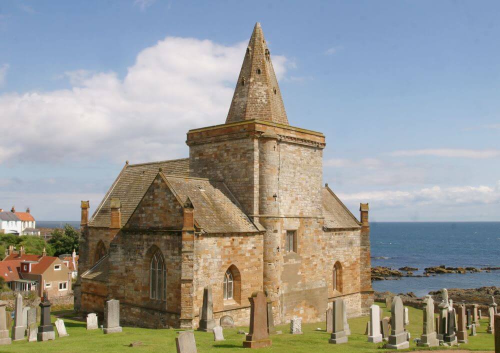 St Monans Auld Kirk Stone church on a hill overlooking the sea, surrounded by old gravestones.